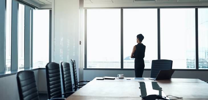 Female federal employee looking out a window in her office