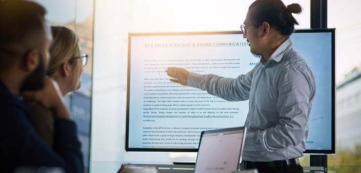 Young company employee giving a presentation to his seniors