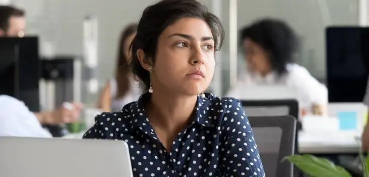 Visually upset private sector employee sitting at her desk